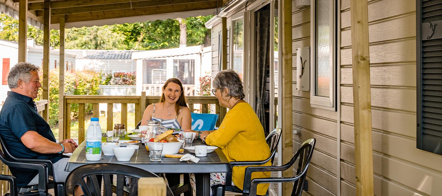 Famille sur la terrasse de son mobil home camping La Réserve